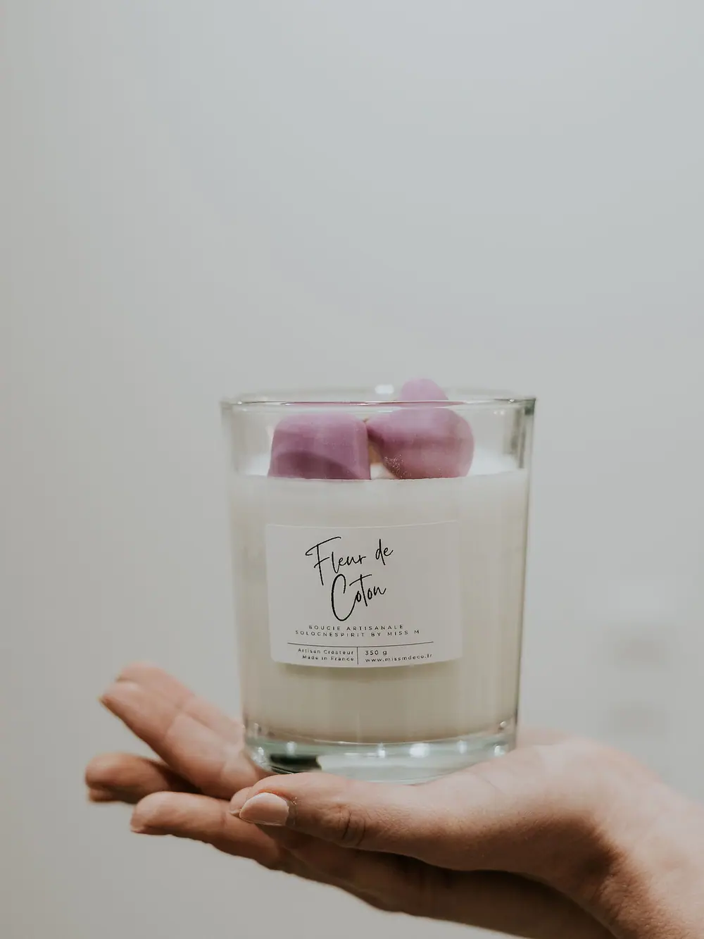 Bougie Fleur de coton et fondants parfumés tenus dans une main