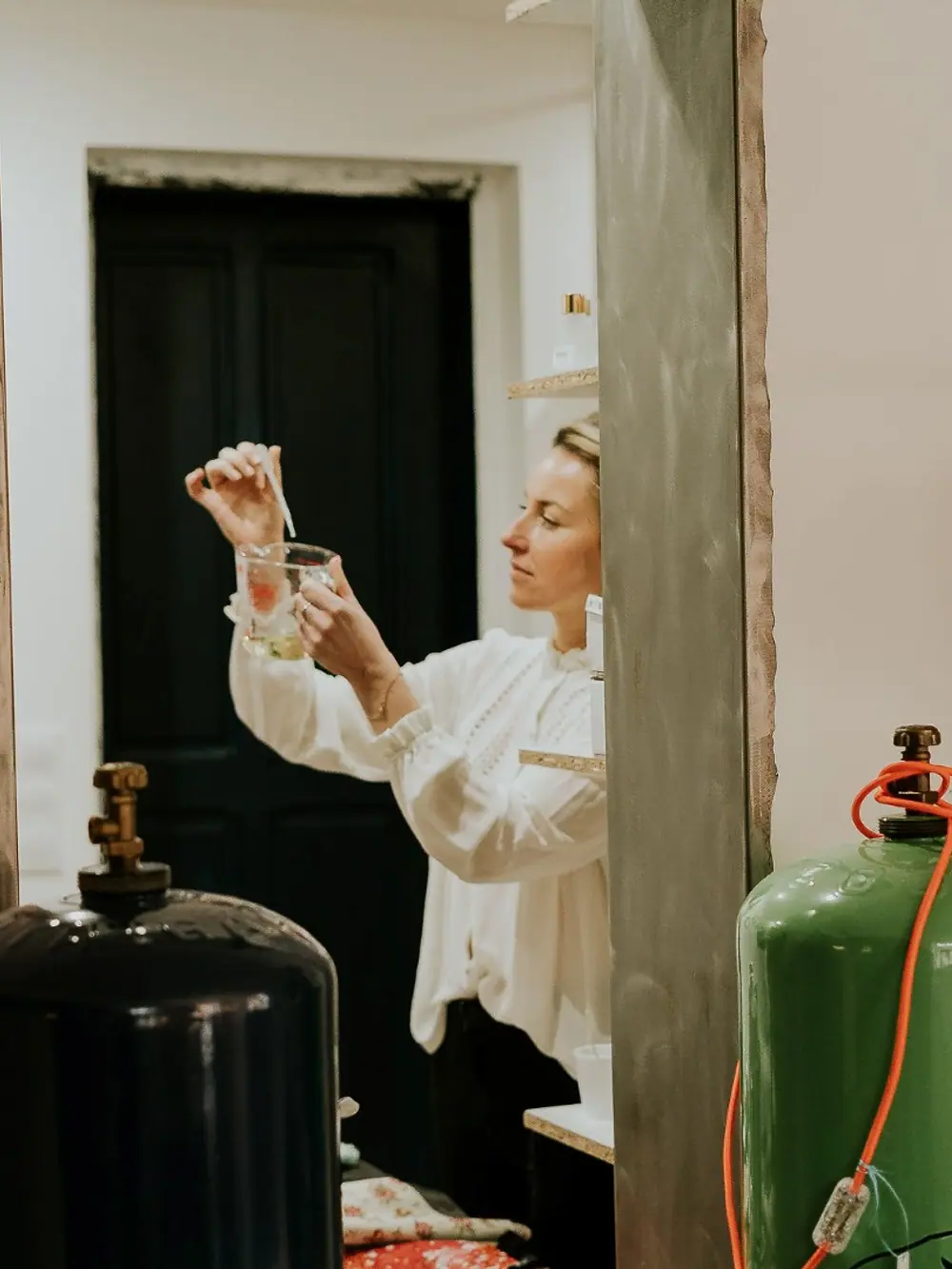 Margo près des cuves de cire de l’atelier