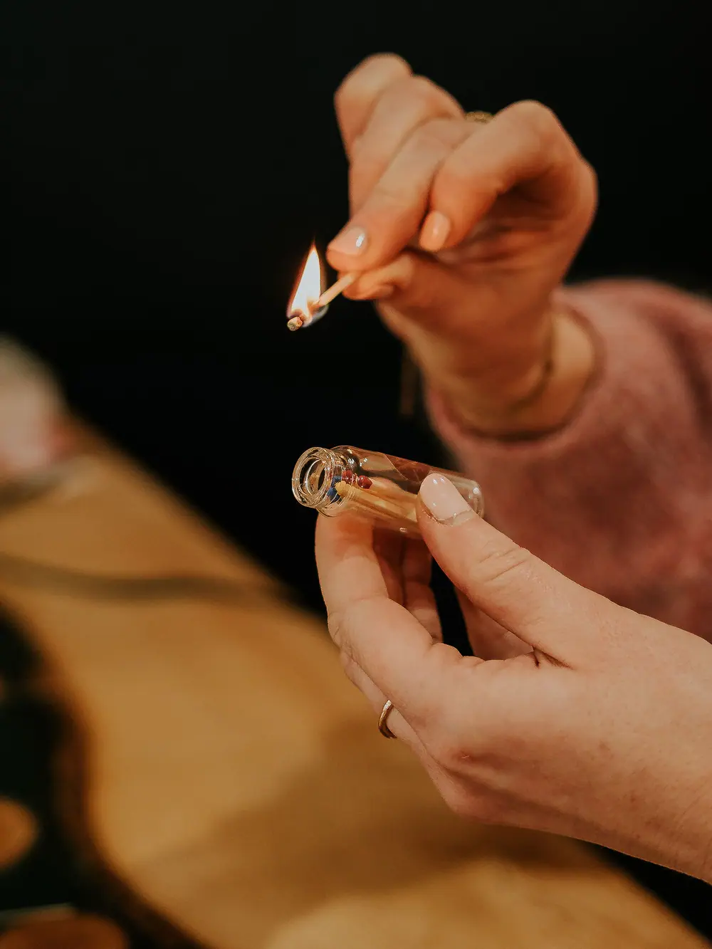 Main craquant une allumette au-dessus d’une bougie