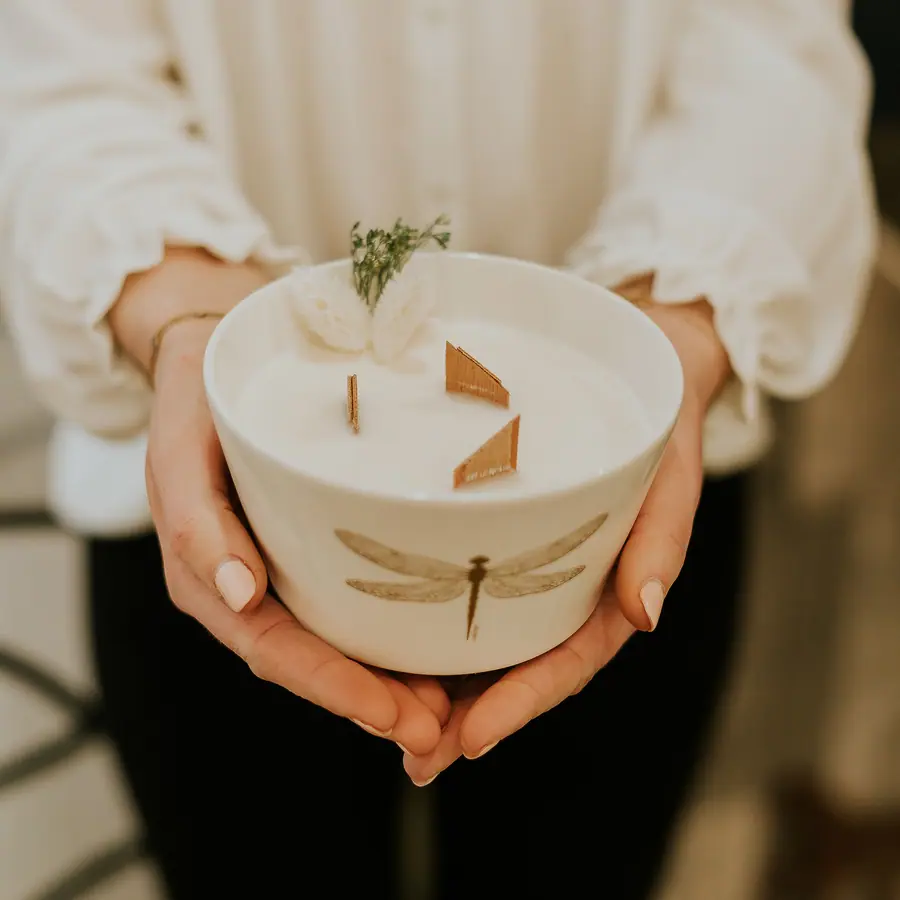 Bougie coulée dans une coupelle de céramique, tenue à deux mains