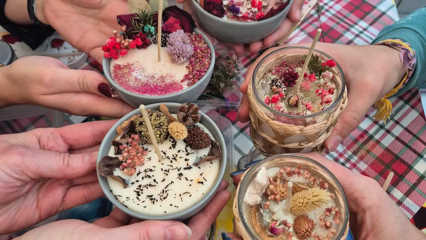 Participants disposant des fleurs séchées sur leurs bougies lors d’un atelier de groupe