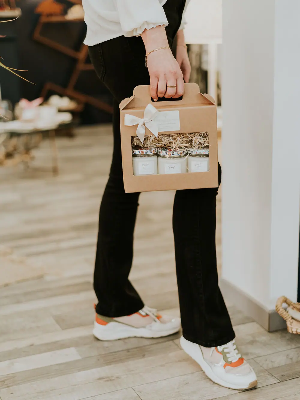 Cliente emportant son coffret de bougies artisanales à la sortie de l’atelier